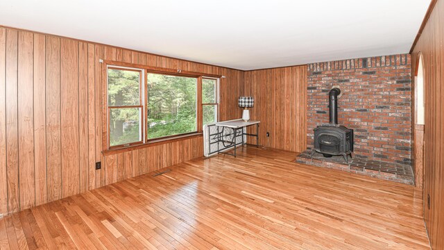 68 Hannibal Cir, Denmark, ME 04022 - unfurnished living room with wood-type flooring, wooden walls, and a wood stove