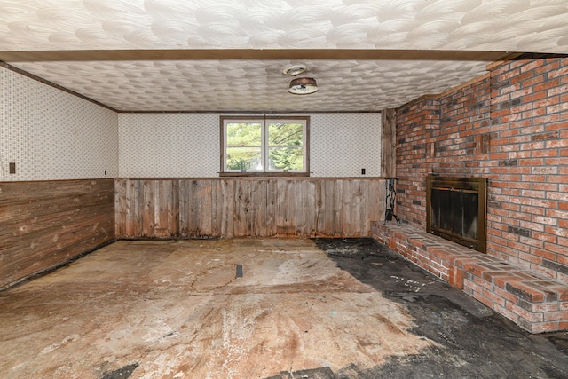68 Hannibal Cir, Denmark, ME 04022 - unfurnished living room featuring a brick fireplace, wallpapered walls, and a wainscoted wall
