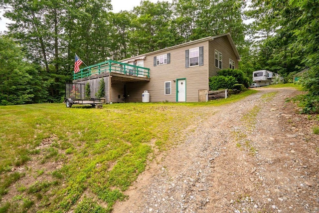1080 Old Augusta Rd, Waldoboro, ME 04572 - back of property with a wooden deck, dirt driveway, a yard, and view of scattered trees