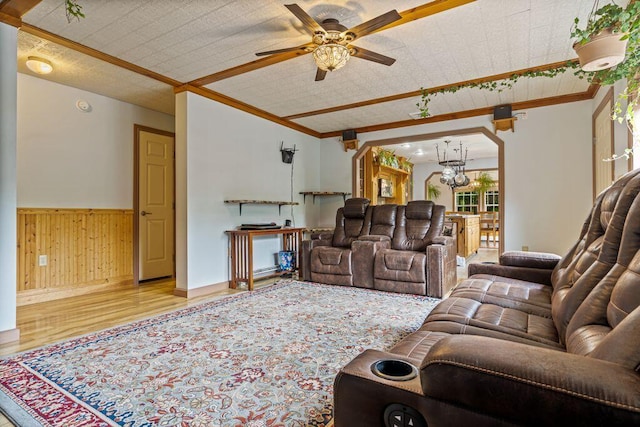 1080 Old Augusta Rd, Waldoboro, ME 04572 - living room with wood finished floors, a ceiling fan, ornamental molding, wood walls, and a chandelier