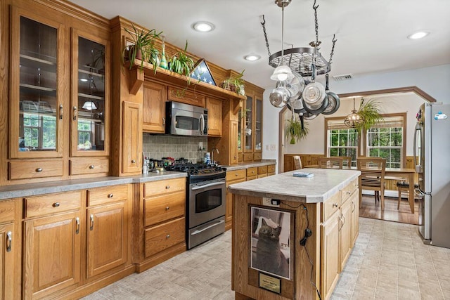 1080 Old Augusta Rd, Waldoboro, ME 04572 - kitchen featuring appliances with stainless steel finishes, a chandelier, light countertops, a kitchen island, and tasteful backsplash