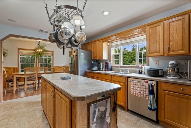 1080 Old Augusta Rd, Waldoboro, ME 04572 - kitchen with stainless steel appliances, wainscoting, a center island, healthy amount of natural light, and brown cabinets