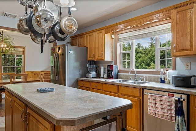 1080 Old Augusta Rd, Waldoboro, ME 04572 - kitchen featuring stainless steel refrigerator with ice dispenser, light countertops, a center island, brown cabinetry, and dishwashing machine