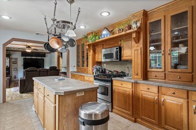 1080 Old Augusta Rd, Waldoboro, ME 04572 - kitchen featuring appliances with stainless steel finishes, a center island, backsplash, recessed lighting, and glass insert cabinets