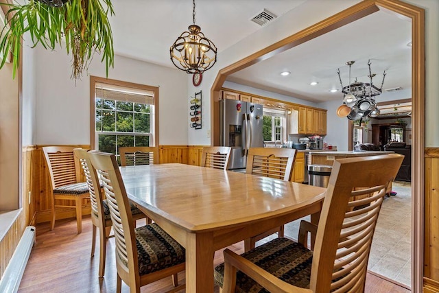 1080 Old Augusta Rd, Waldoboro, ME 04572 - dining space featuring a chandelier, a baseboard radiator, healthy amount of natural light, wainscoting, and light wood finished floors