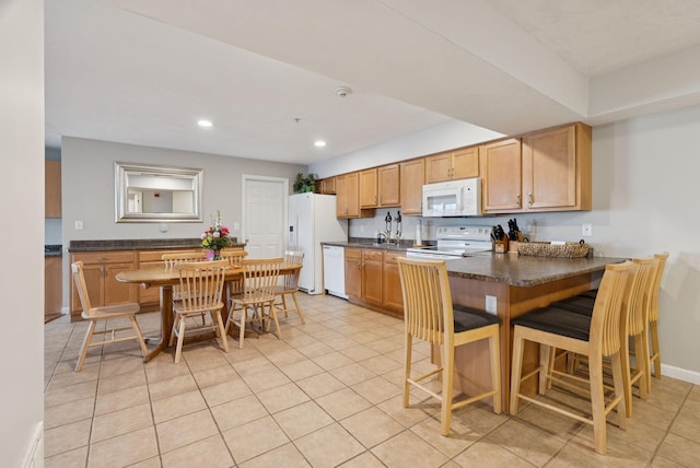 170 E Grand Ave Unit 8, Old Orchard Beach, ME 04064 - kitchen with white appliances, dark countertops, recessed lighting, light tile patterned floors, and a peninsula