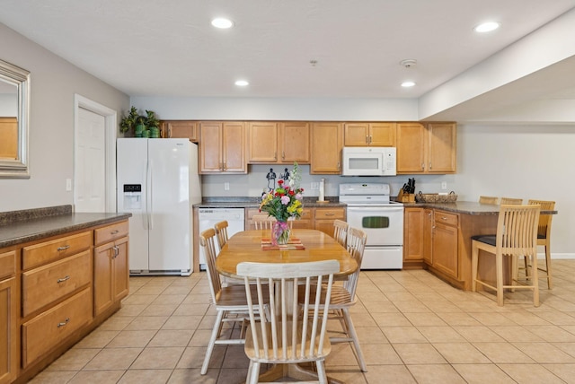 170 E Grand Ave Unit 8, Old Orchard Beach, ME 04064 - kitchen featuring white appliances, dark countertops, a peninsula, light tile patterned floors, and recessed lighting