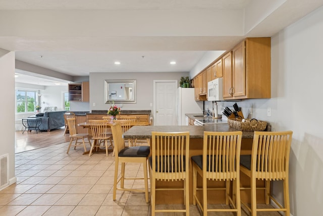 170 E Grand Ave Unit 8, Old Orchard Beach, ME 04064 - kitchen with white appliances, dark countertops, a peninsula, recessed lighting, and light tile patterned floors