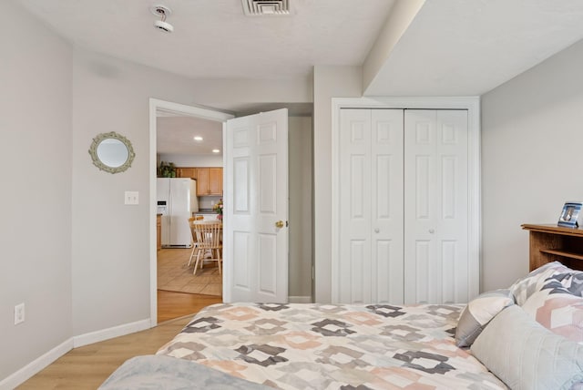 170 E Grand Ave Unit 8, Old Orchard Beach, ME 04064 - bedroom featuring white fridge with ice dispenser, light wood finished floors, a closet, and recessed lighting