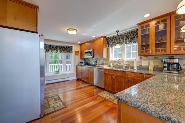 11 Washington Ct, Naples, ME 04055 - kitchen with stainless steel appliances, a baseboard radiator, brown cabinetry, tasteful backsplash, and light wood-style floors
