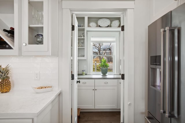 126 Mile Stretch Rd, Biddeford, ME 04005 - kitchen featuring high quality fridge, decorative backsplash, white cabinets, glass insert cabinets, and dark wood-type flooring