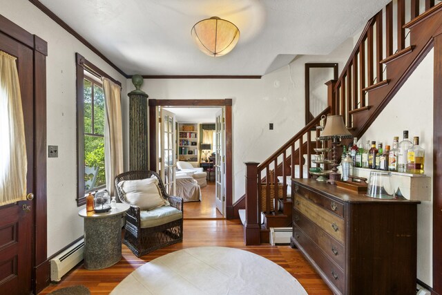 115 Babbidge Rd, Islesboro, ME 04848 - entryway with a baseboard heating unit, wood finished floors, stairs, and ornamental molding