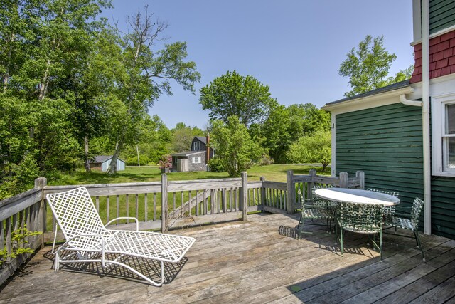 115 Babbidge Rd, Islesboro, ME 04848 - wooden deck with outdoor dining area, a shed, and a yard