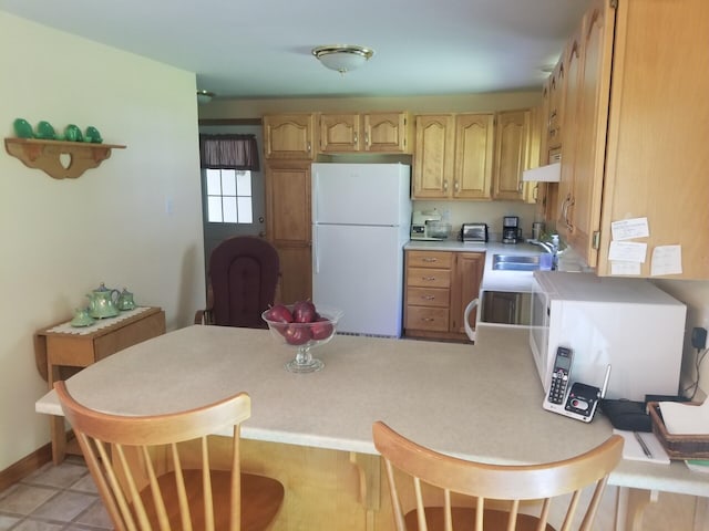 14 Reach Rd, Presque Isle, ME 04769 - kitchen with freestanding refrigerator, a peninsula, light countertops, a kitchen bar, and light brown cabinets
