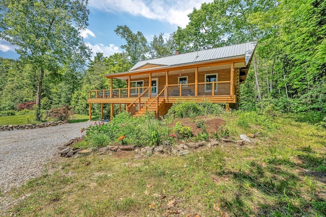 221 Gates Rd, Jefferson, ME 04348 - cabin featuring log siding, gravel driveway, a metal roof, a porch, and stairway