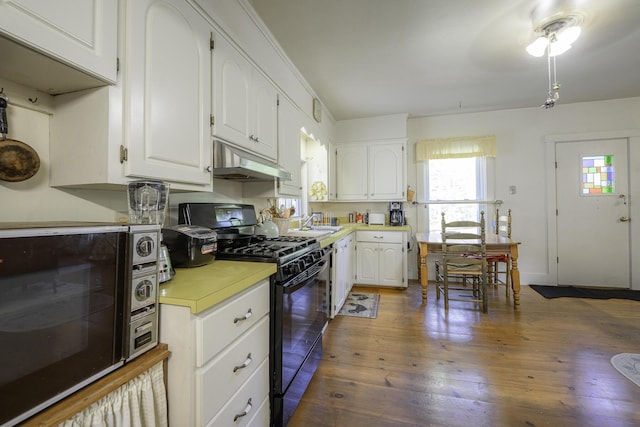 878 State Route 32, Bristol, ME 04564 - kitchen with black appliances, under cabinet range hood, light countertops, and white cabinets
