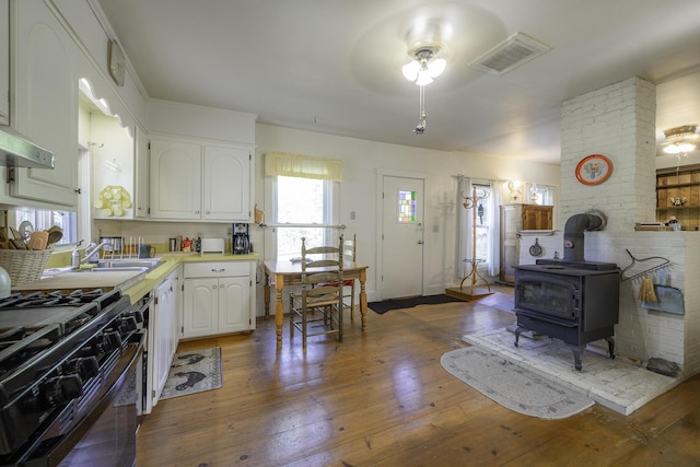 878 State Route 32, Bristol, ME 04564 - kitchen with gas stove, a ceiling fan, white cabinetry, light countertops, and hardwood / wood-style floors
