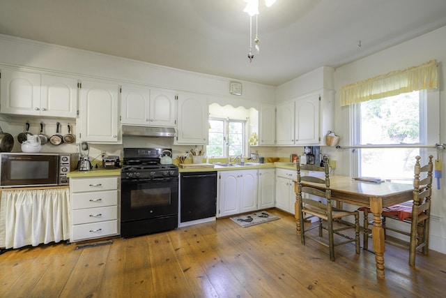 878 State Route 32, Bristol, ME 04564 - kitchen with black appliances, under cabinet range hood, white cabinetry, light countertops, and plenty of natural light