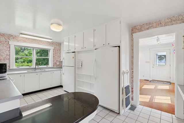 428 Webbs Mills Rd, Raymond, ME 04071 - kitchen featuring freestanding refrigerator, light tile patterned floors, and white cabinetry