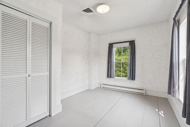 428 Webbs Mills Rd, Raymond, ME 04071 - unfurnished bedroom featuring a baseboard heating unit, a closet, wood finished floors, and crown molding