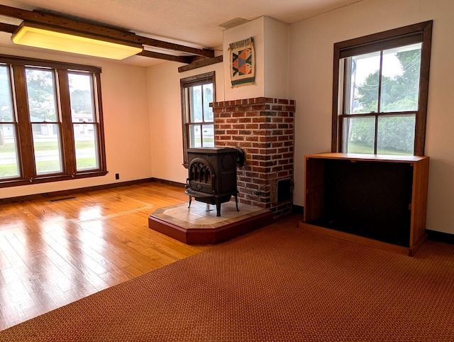 428 Webbs Mills Rd, Raymond, ME 04071 - living room featuring a wood stove, wood finished floors, and beam ceiling