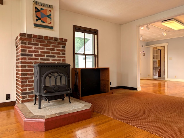 428 Webbs Mills Rd, Raymond, ME 04071 - living area featuring a wood stove, wood-type flooring, and track lighting