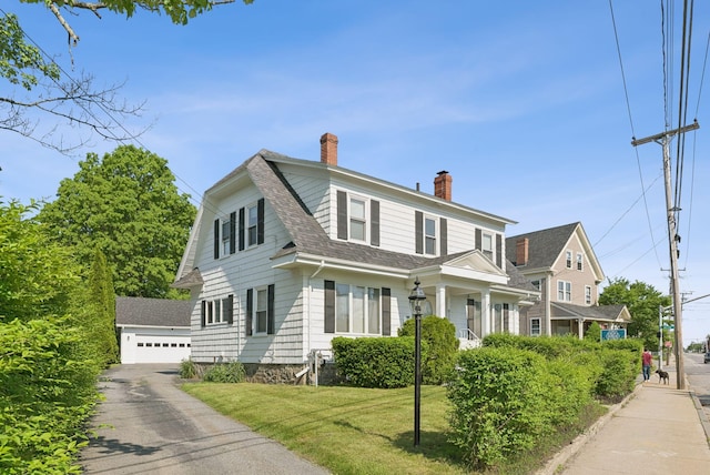 930 Forest Ave, Portland, ME 04103 - colonial inspired home with a chimney, roof with shingles, an outdoor structure, a garage, and a front lawn