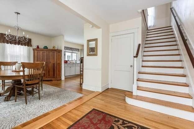 930 Forest Ave, Portland, ME 04103 - dining space featuring a chandelier, wood finished floors, and stairs