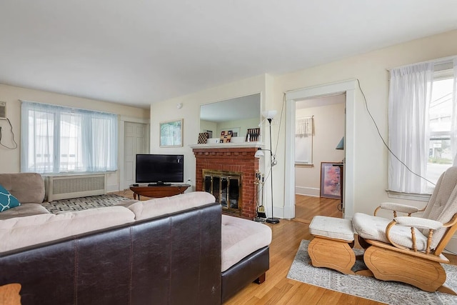 930 Forest Ave, Portland, ME 04103 - living area with radiator heating unit, a fireplace, and light wood finished floors