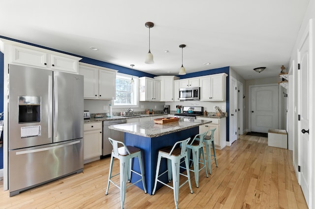 50 Carlisle Ln, Wells, ME 04090 - kitchen with stainless steel appliances, recessed lighting, light wood-type flooring, a kitchen bar, and white cabinets
