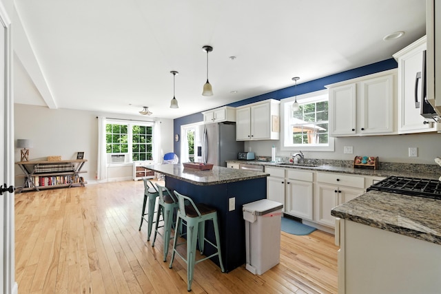 50 Carlisle Ln, Wells, ME 04090 - kitchen with appliances with stainless steel finishes, light wood-style flooring, a kitchen island, white cabinets, and plenty of natural light