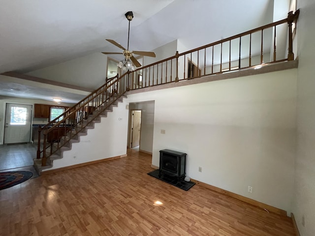 29 Range Rd, Brunswick, ME 04011 - unfurnished living room featuring stairs, a wood stove, wood finished floors, ceiling fan, and high vaulted ceiling