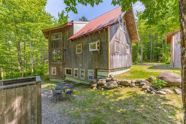 22 Woodpecker Ln, Embden, ME 04958 - rear view of property with a metal roof and outdoor dining space