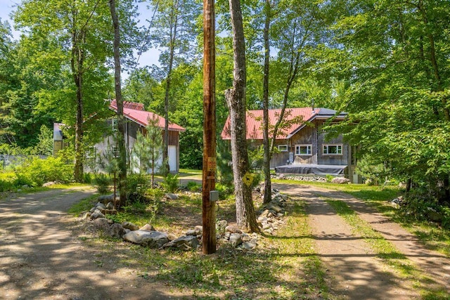 22 Woodpecker Ln, Embden, ME 04958 - view of front of property with dirt driveway, a metal roof, and an outbuilding