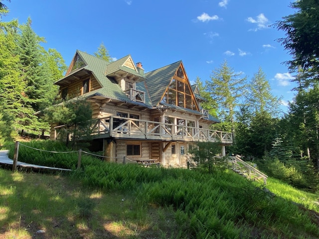 378 Black Point Rd, Beaver Cove, ME 04441 - back of property with a chimney, log siding, and a wooden deck