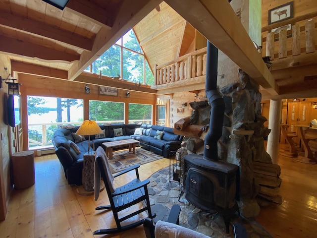 378 Black Point Rd, Beaver Cove, ME 04441 - living room featuring a wood stove, light wood-style floors, high vaulted ceiling, plenty of natural light, and a wooden ceiling with exposed beams