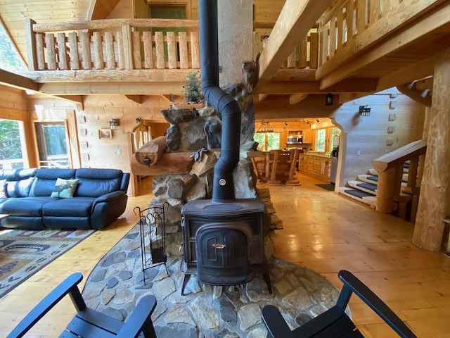 378 Black Point Rd, Beaver Cove, ME 04441 - living room with a wood stove, hardwood / wood-style floors, wood walls, and stairway