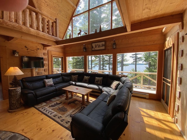 378 Black Point Rd, Beaver Cove, ME 04441 - living area with a baseboard radiator, wood walls, a water view, wood-type flooring, and plenty of natural light