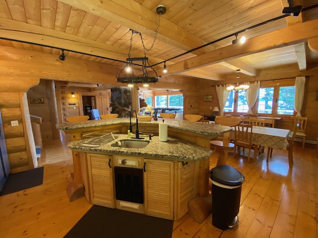 378 Black Point Rd, Beaver Cove, ME 04441 - kitchen with a wooden ceiling with exposed beams, a chandelier, light wood-style floors, a kitchen island with sink, and healthy amount of natural light