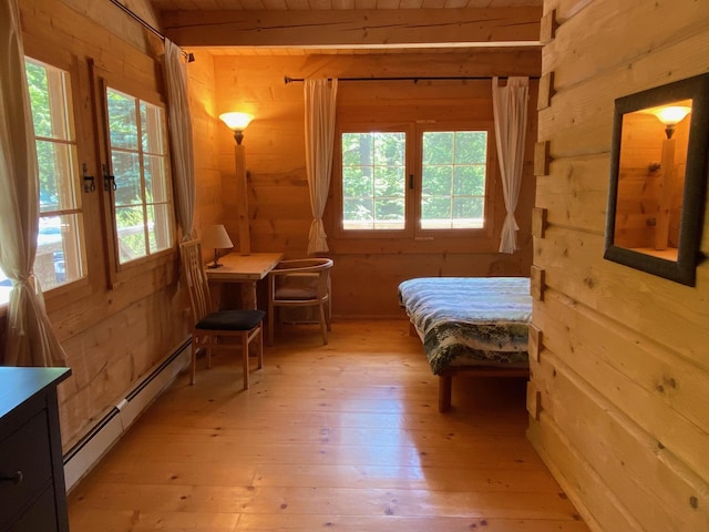 378 Black Point Rd, Beaver Cove, ME 04441 - bedroom with a baseboard radiator, wood walls, light wood-type flooring, and wooden ceiling