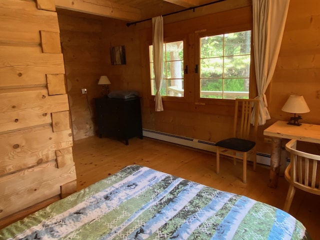 378 Black Point Rd, Beaver Cove, ME 04441 - bedroom featuring wood finished floors, a baseboard radiator, and wooden walls