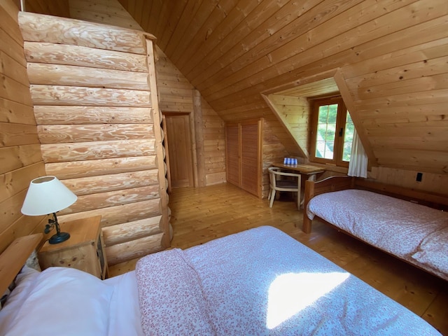 378 Black Point Rd, Beaver Cove, ME 04441 - bedroom featuring wooden ceiling, hardwood / wood-style flooring, vaulted ceiling, wooden walls, and log walls