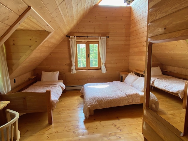 378 Black Point Rd, Beaver Cove, ME 04441 - bedroom with vaulted ceiling, hardwood / wood-style floors, wooden walls, wooden ceiling, and a baseboard radiator