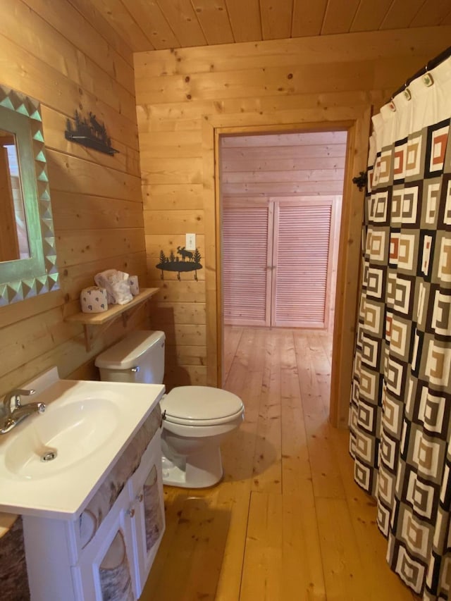 378 Black Point Rd, Beaver Cove, ME 04441 - full bath featuring wood walls, hardwood / wood-style floors, wooden ceiling, vanity, and a shower with curtain