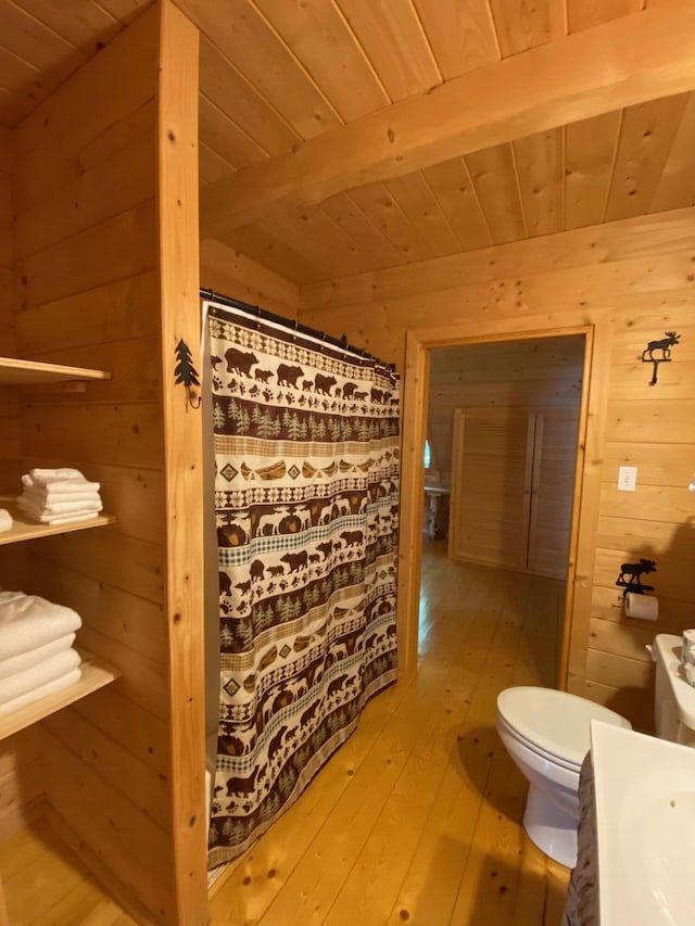 378 Black Point Rd, Beaver Cove, ME 04441 - bathroom featuring a wood ceiling with exposed beams, wood walls, wood-type flooring, and vanity