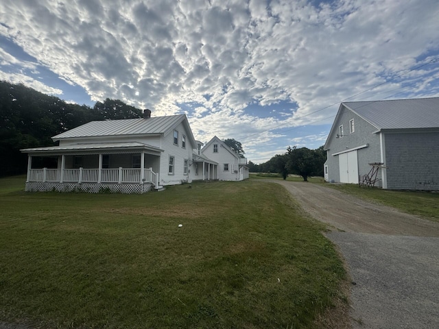 205 Bangor Rd, Unity, ME 04988 - view of side of property featuring a porch, dirt driveway, a yard, a chimney, and a metal roof