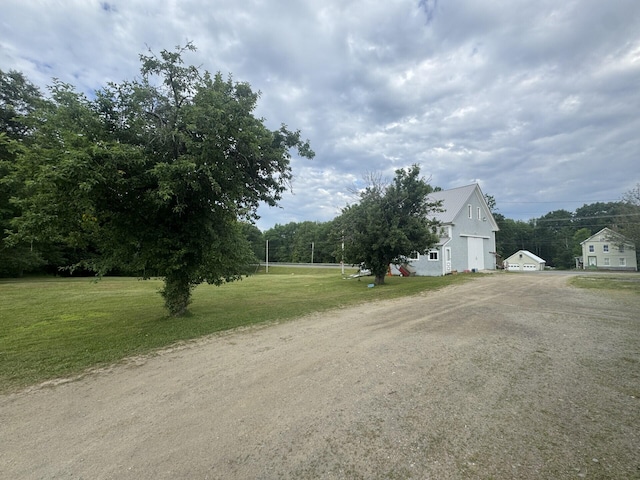 205 Bangor Rd, Unity, ME 04988 - view of green lawn featuring driveway, a garage, and an outbuilding