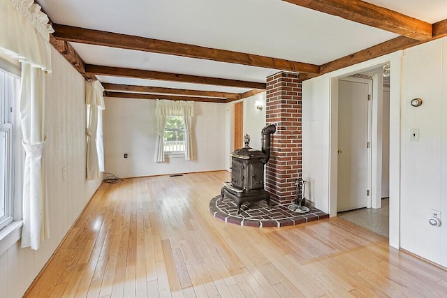 205 Bangor Rd, Unity, ME 04988 - unfurnished living room with light wood finished floors, beam ceiling, and a wood stove