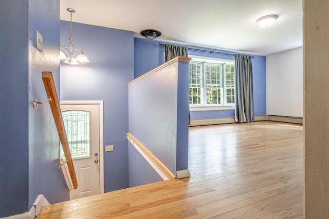 1 Chestnut Ave, Windham, ME 04062 - staircase featuring wood finished floors, a chandelier, baseboard heating, and a baseboard radiator