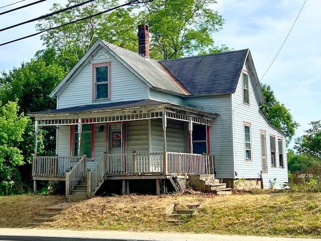 363 Lisbon St, Lisbon, ME 04250 - view of front facade with a porch, a chimney, and roof with shingles